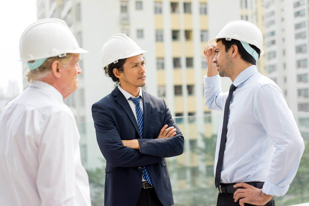 Engenheiros civis conversando a respeito da estrutura de um prédio para perícia e laudos técnicos de engenharia